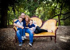 a family sitting on a bench in the woods