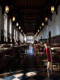 an empty dining hall with checkered floor and high ceilings is seen in this image