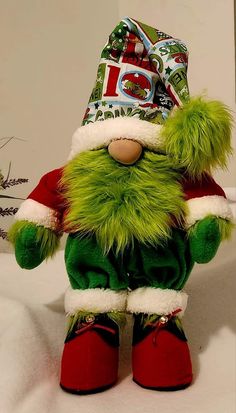 a green stuffed animal wearing a santa hat