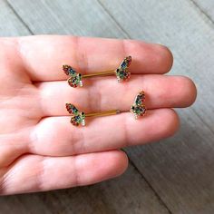 three pairs of butterfly shaped piercings are shown in the palm