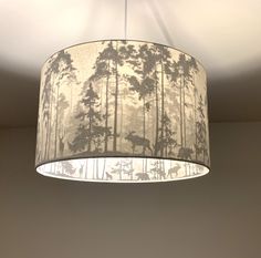 a lampshade hanging from the ceiling in a room with a deer and trees print on it