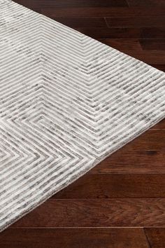 a white rug on top of a wooden floor