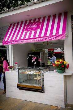 a food stand with pink and white striped awning