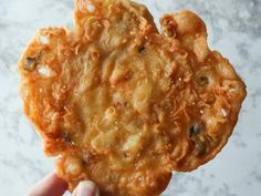 a person holding up a fried food item