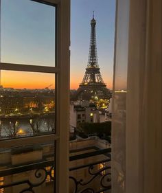 the eiffel tower is lit up at night from an apartment in paris, france