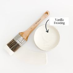 a paintbrush and bowl with the words vanilla frosting on it next to a wooden brush