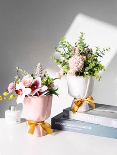 two vases filled with flowers sitting on top of a table next to each other