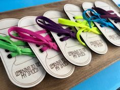 four wooden tags with different colored ribbons on them