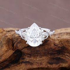 an engagement ring with a pear shaped diamond