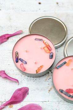 three tins filled with different types of candies on top of a white table