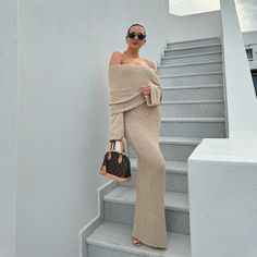 a woman standing on some stairs with her handbag