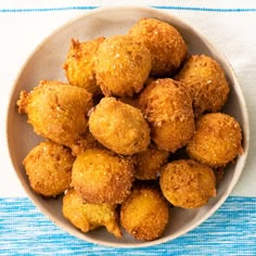 a white bowl filled with fried food on top of a blue and white table cloth