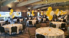 tables and chairs are set up with white tablecloths and yellow balloons