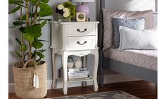 a bedroom with a bed, nightstand and potted plant on the floor next to it