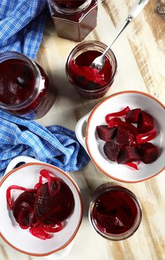 three bowls filled with beets on top of a wooden table