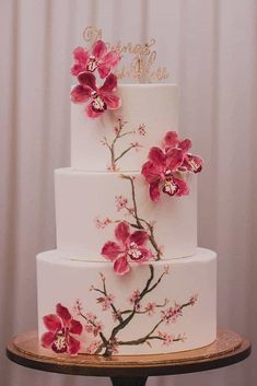 a three tiered cake with pink flowers on it