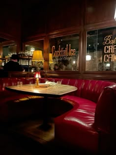 a restaurant with red leather couches and wooden tables