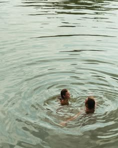 two people are swimming in the water together