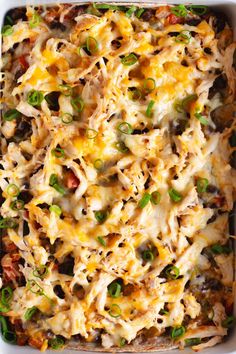 a casserole dish filled with chicken, cheese and green onions in a pan