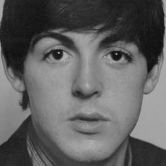 an old black and white photo of a young man wearing a suit with his eyes wide open