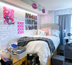 a bedroom with white brick walls and lots of pictures on the wall above the bed