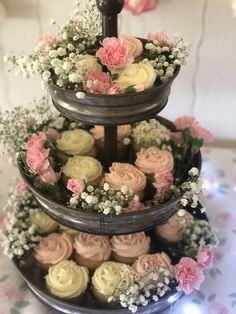 three tiered tray with cupcakes and baby's breath flowers