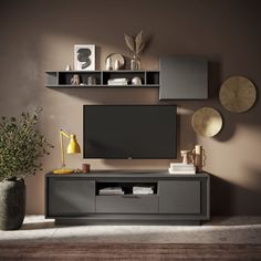 a living room with a large tv on the wall and some plants in vases