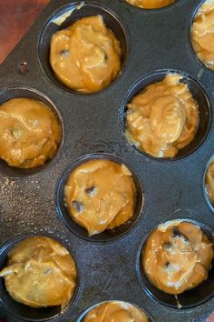 a muffin tin filled with cupcakes covered in caramel colored icing