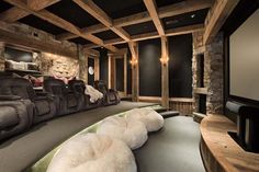 an image of a home theater in the middle of a room with stone walls and wood beams