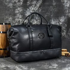 black leather duffle bag with monogrammed initials