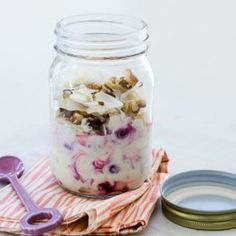 a jar filled with granola sitting on top of a table next to other items