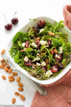 a salad in a bowl with almonds on the side