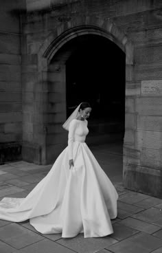 a woman in a wedding dress is standing outside