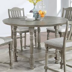 a dining room table with chairs and a vase on top of the table in front of it