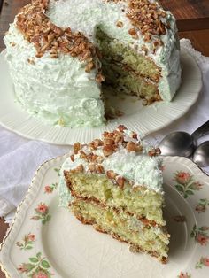 there is a cake with white frosting and walnuts on the top it has one slice taken out