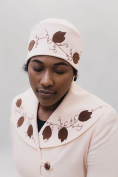 Black woman wearing a pink wool cloche hat with brown feather applique and embroidery on it. Decorative Stitching, Hat Design, Coat Patterns, Fabric Beads, Contrast Collar, Wide Cuff, Stenciling, Silk Twill, Cotton Velvet