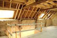 an unfinished room with wooden beams and exposed walls