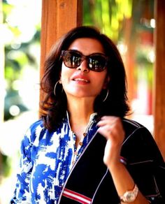 a woman wearing sunglasses and a blue shirt