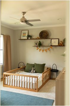 a baby's room with a crib, bed and shelves on the wall