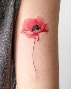 a woman's arm with a red flower tattoo on the left side of her arm