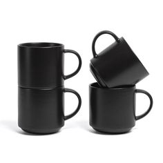 three black coffee mugs sitting next to each other on a white surface with one cup in the middle