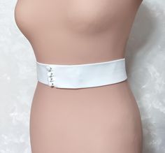 The Light Ivory Bridal Belt Sash is a stunning accessory for any bride looking to enhance their wedding dress. Made from an elastic base covered with premium matte satin, this belt offers a touch of elegance and sophistication. It features handmade buttons, covered with fabric that perfectly matches the belt, adding a unique and personalized touch to your bridal ensemble. Width 0.6-3 inches Fabric: Italian matte satin Color: light ivory (shown in the photo) 1. Mulberry silk (Light ivory) - off white with a warm shade 2. Mulberry Silk (White) - neutral white 3. Matte satin (light ivory) - off white with a warm shade 4. Satin Duchess (Ivory) - standard ivory (main photo of the belt) 5. Satin Duchess (Light Ivory) - standard light ivory 6. Satin Duchess (White) - bright white with a cool shad Belt For Wedding Dress, Wedding Dress Ivory, Handmade Buttons, Bridal Sash Belt, Satin Belt, Wedding Belt, Wedding Sash Belt, For Wedding Dress, Ivory Bridal