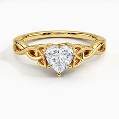 a heart shaped diamond ring with an intricate design on the band, set in 18k yellow gold