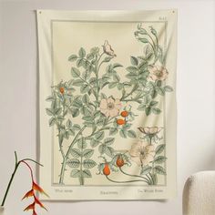 a wall hanging on the side of a white wall with flowers and butterflies in it