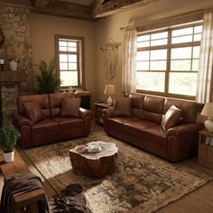 a living room with two couches and a coffee table in front of a fireplace