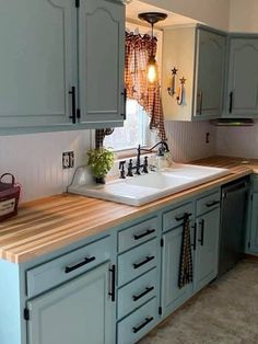 a kitchen with blue cabinets and wooden counter tops