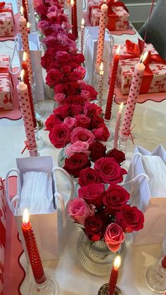 a long table with red roses and candles