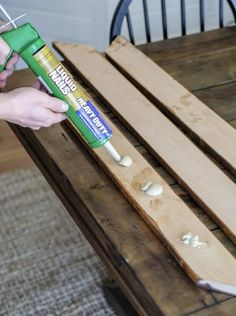 someone using glue to paint wood planks on a table