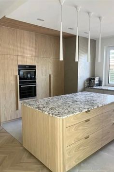 a kitchen with an island, stove and oven in the middle of it's countertops