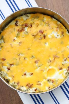 a casserole dish with cheese and meat in it on a blue and white towel